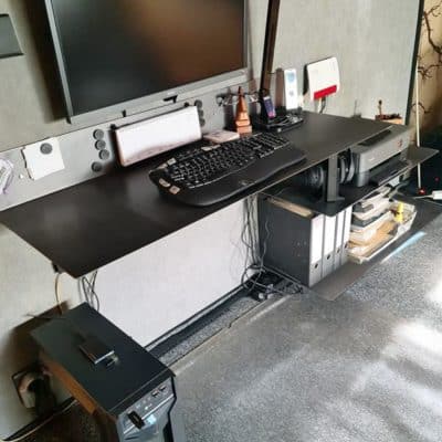 Moderner Schreibtisch aus gezundertem Schwarzblech mit klaren Linien und industriellem Design, ausgestattet mit einer glatten Arbeitsfläche und stabilen Stahlbeinen.