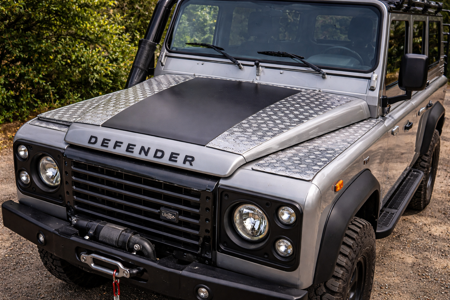 Land Rover Defender mit Aluriffelblech-Akzenten auf der Motorhaube.