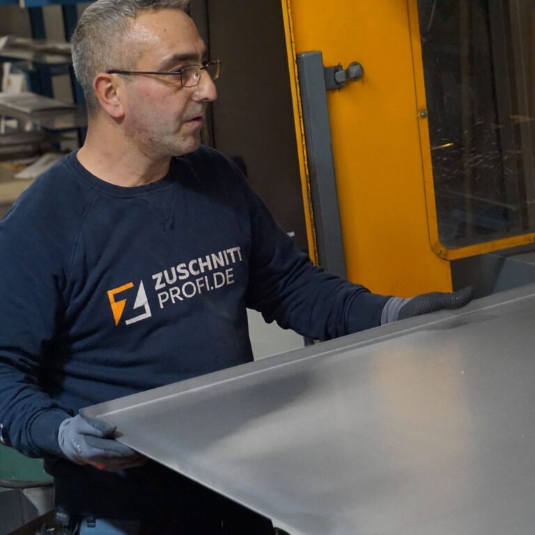 Mitarbeiter fertigt Edelstahlplatte bei Zuschnittprofi.de.