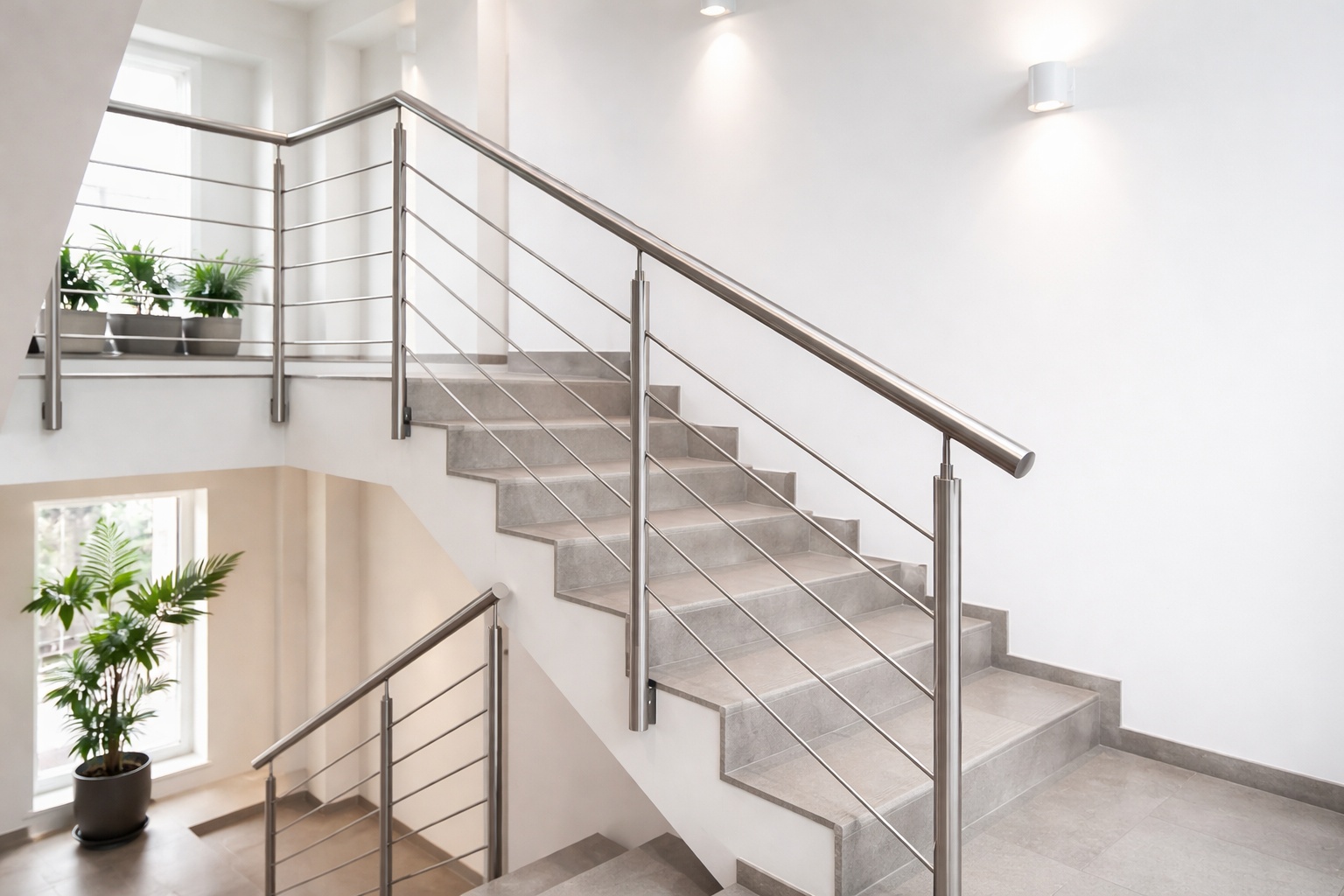 Ein schlichtes Geländer aus Edelstahl-Rundrohr begleitet eine moderne Treppe im Wohnhaus.
