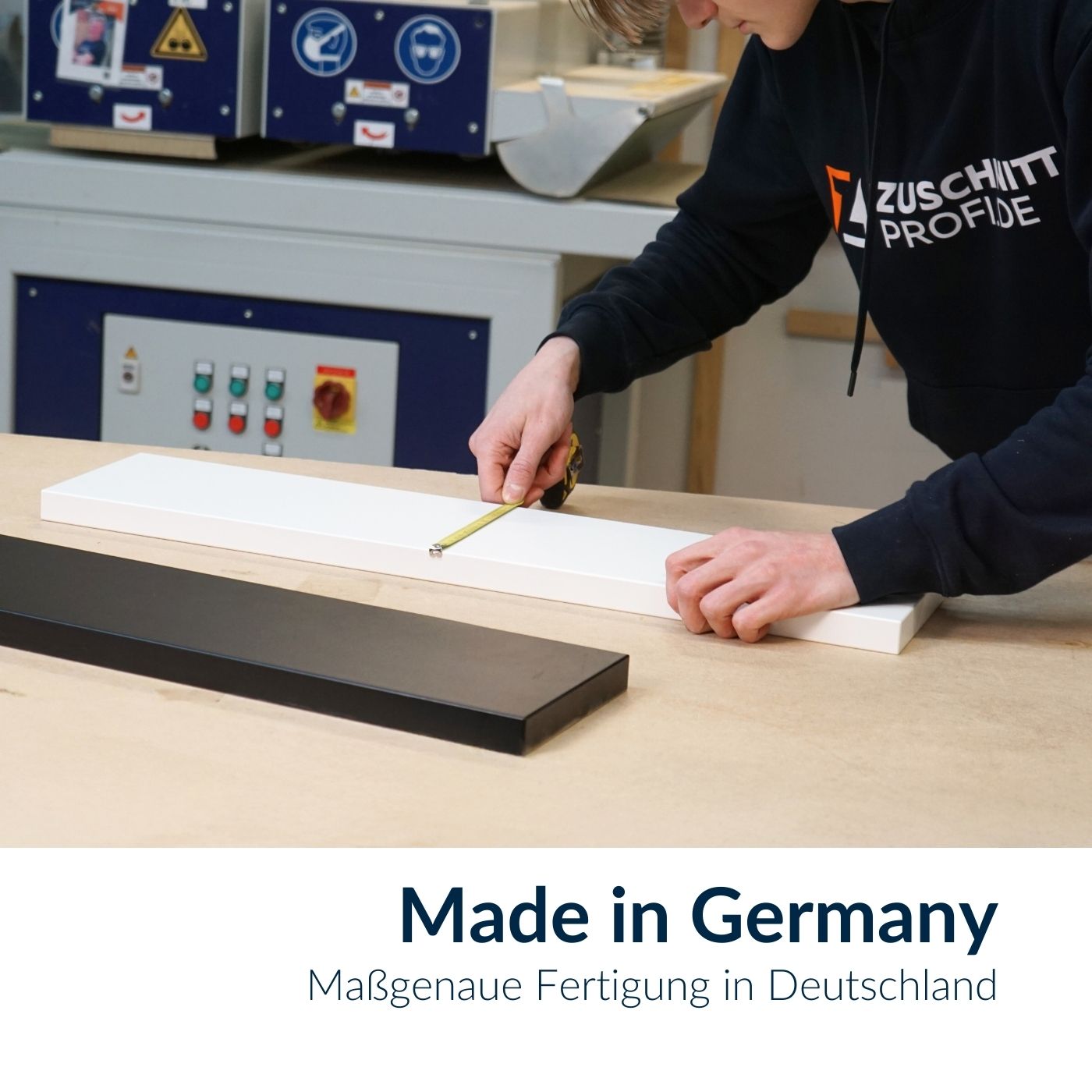 Ein Mitarbeiter misst eine weiße Dekorplatte bei der Fertigung nach Maß.