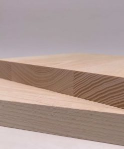 Twee lichte esdoornen platen liggen kruislings op een glad oppervlak.