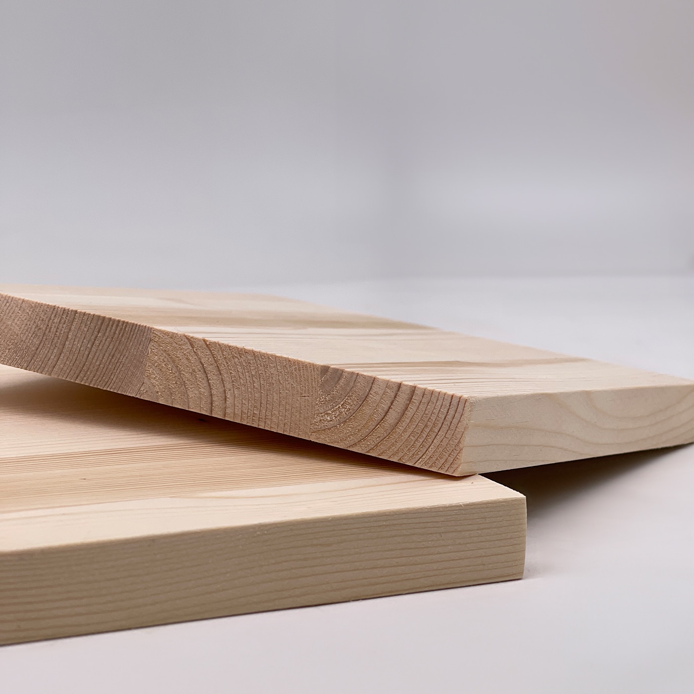 Zwei Fichten Platten liegen übereinander und zeigen eine natürliche Holzstruktur.