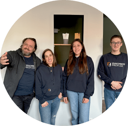 Mehrere Teammitglieder von Zuschnittprofi.de stehen gemeinsam im Büro und präsentieren das Teamgefühl.