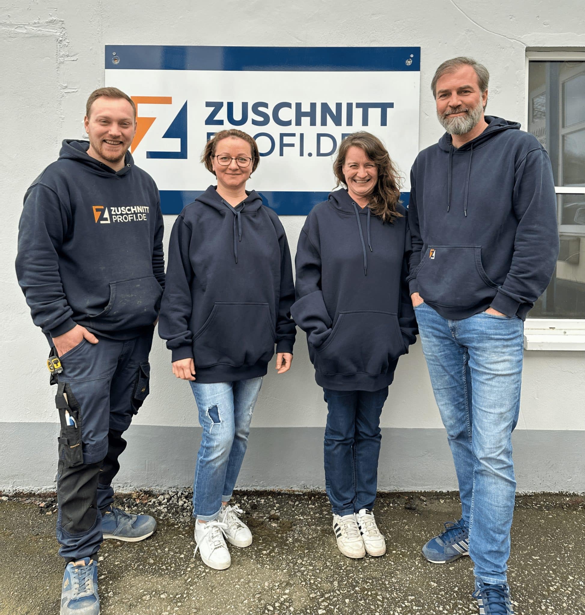 Vier Teammitglieder von Zuschnittprofi.de posieren gemeinsam vor dem Firmengebäude.