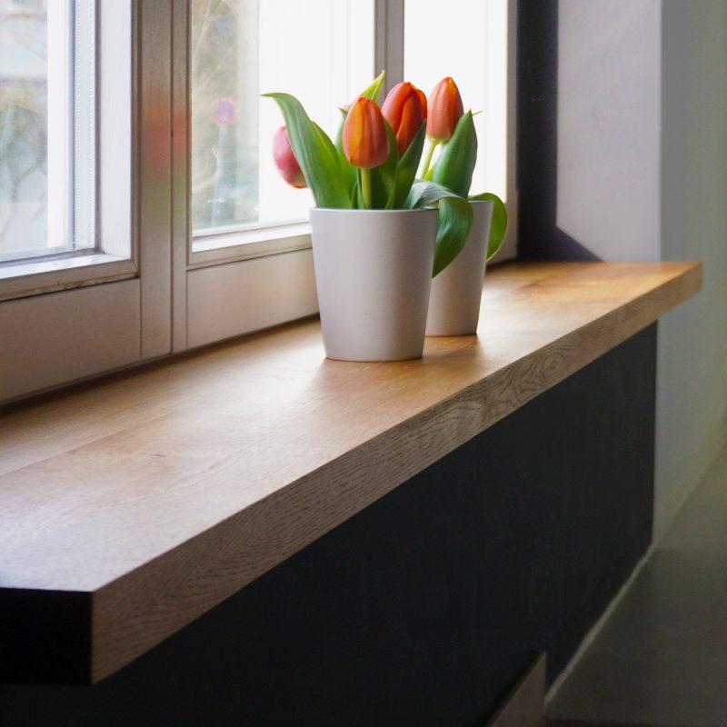 Stilvoll renovierte Fensterbank mit maßgefertigter Abdeckung, modern gestaltet und hochwertig verarbeitet.